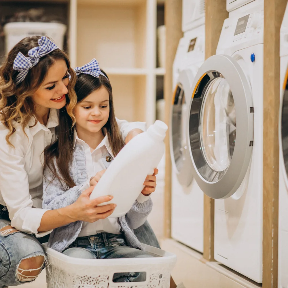 A mother and daughter using the machines together in a self-service laundry